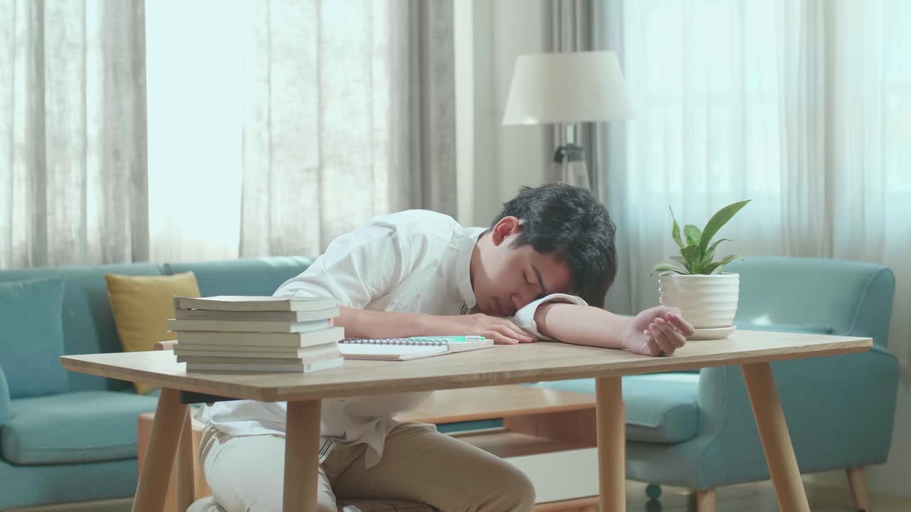 지친 학생이 책상에서 잠을 자고 있습니다.