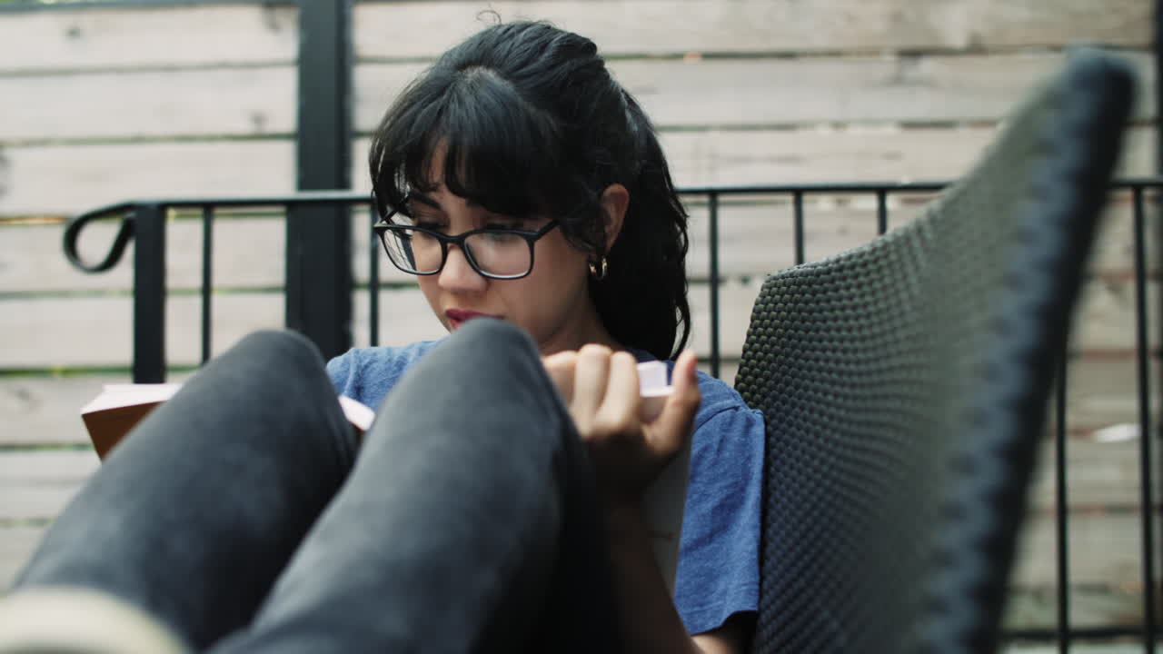 뭔가 슬픈 것을 읽고 밖에 앉아 젊은 라티나 여자