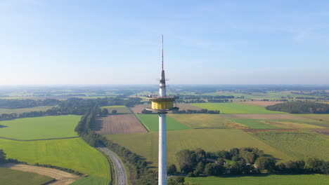 radio and tv tower on the idyllic field in dotternhausen, germany - aerial drone shot