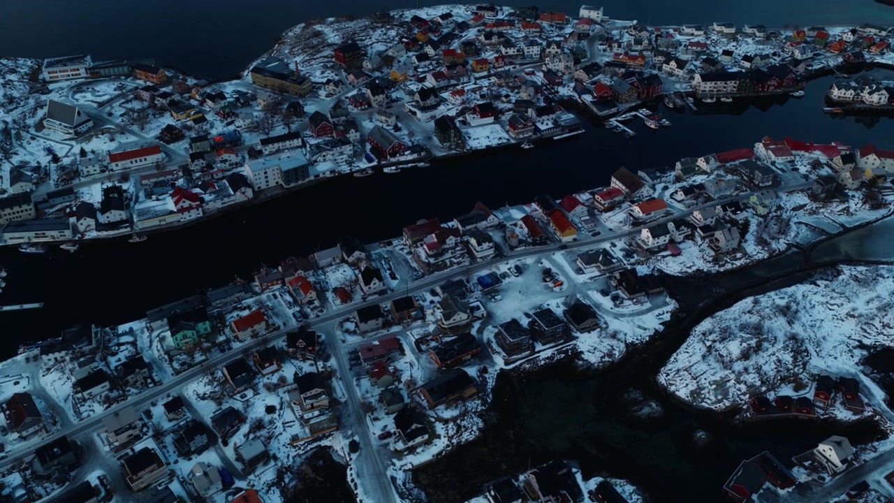 Nærbilde fra luften av snødekte arktiske øyer omgitt av mørke fjordfarvann, tatt med drone.