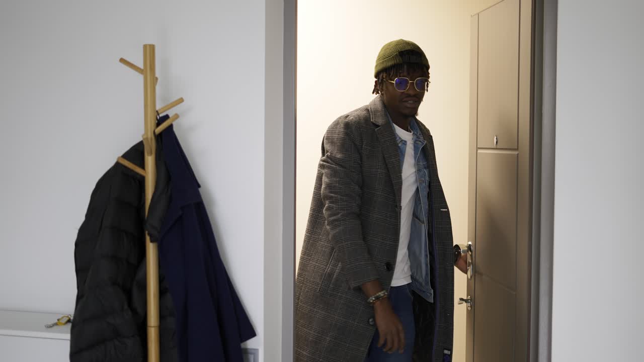 En man i vardagskläder öppnar dörren och går in i huset.