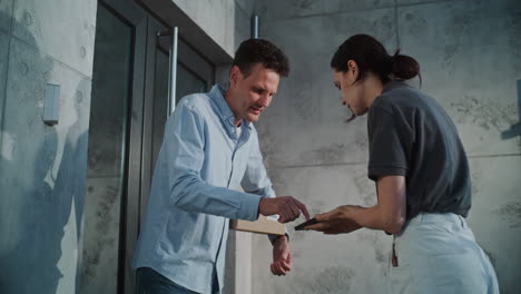 man receiving and signing for a package from a delivery person
