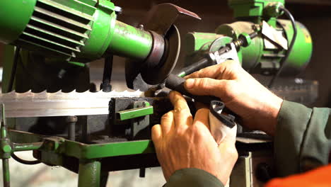 engineer doing maintenance on electric band saw blade sharpener