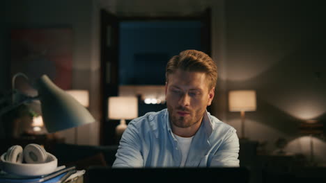 Focused-guy-drinking-tea-at-dark-place-closeup.-Freelancer-looking-pc-monitor