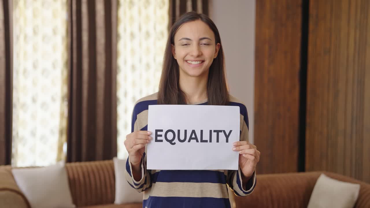 Happy Indian woman holding EQUALITY banner
