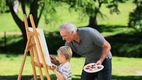 Young-boy-painting-a-white-canvas-with-grandad