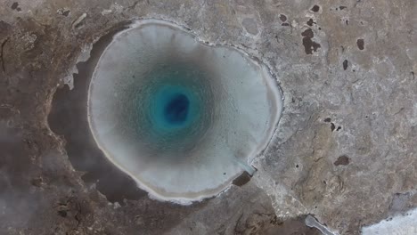 aerial drone shot of the great geysir a geyser in southwestern iceland.