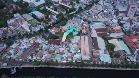 ho chi minh city, vietnam, aerial view on a sunny day featuring the canal green space and rooftops of densely populated crowded residential area and communal buildings