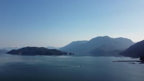 boat cruising with wake on harrison lake on sunny day in fraser valley, canada