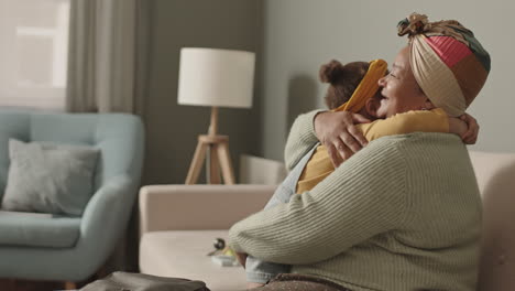 aged african-american woman hugging her granddaughter