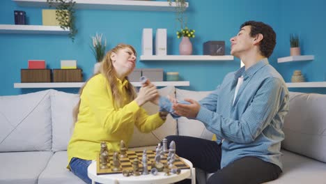 mujer madura alegre y feliz y su hijo jugando al ajedrez juntos en casa.