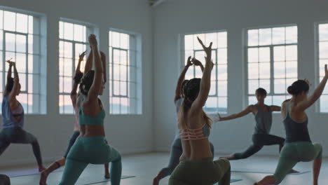 Clase-De-Yoga-De-Mujeres-Sanas-Practicando-Pose-De-Estocada-Creciente-En-El-Gimnasio-Al-Amanecer-Disfrutando-Del-Ejercicio-Temprano-En-La-Mañana