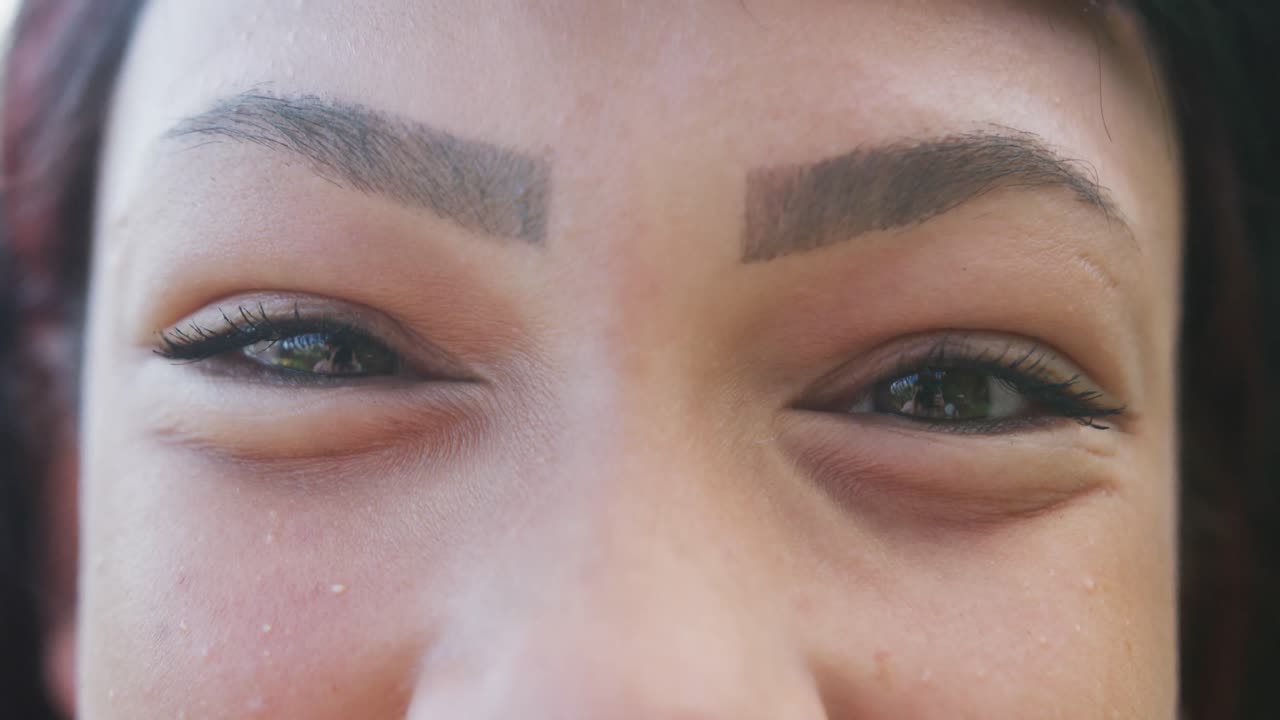 슬로모션으로 카메라를 바라보며 미소 짓는 행복한 이중 인종 십대 소녀의 초상화