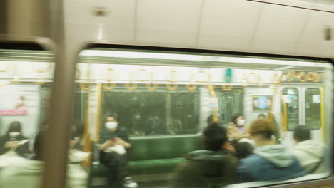 The-rush-of-the-city:-A-metro-arriving-at-a-bustling-Japanese-underground-station