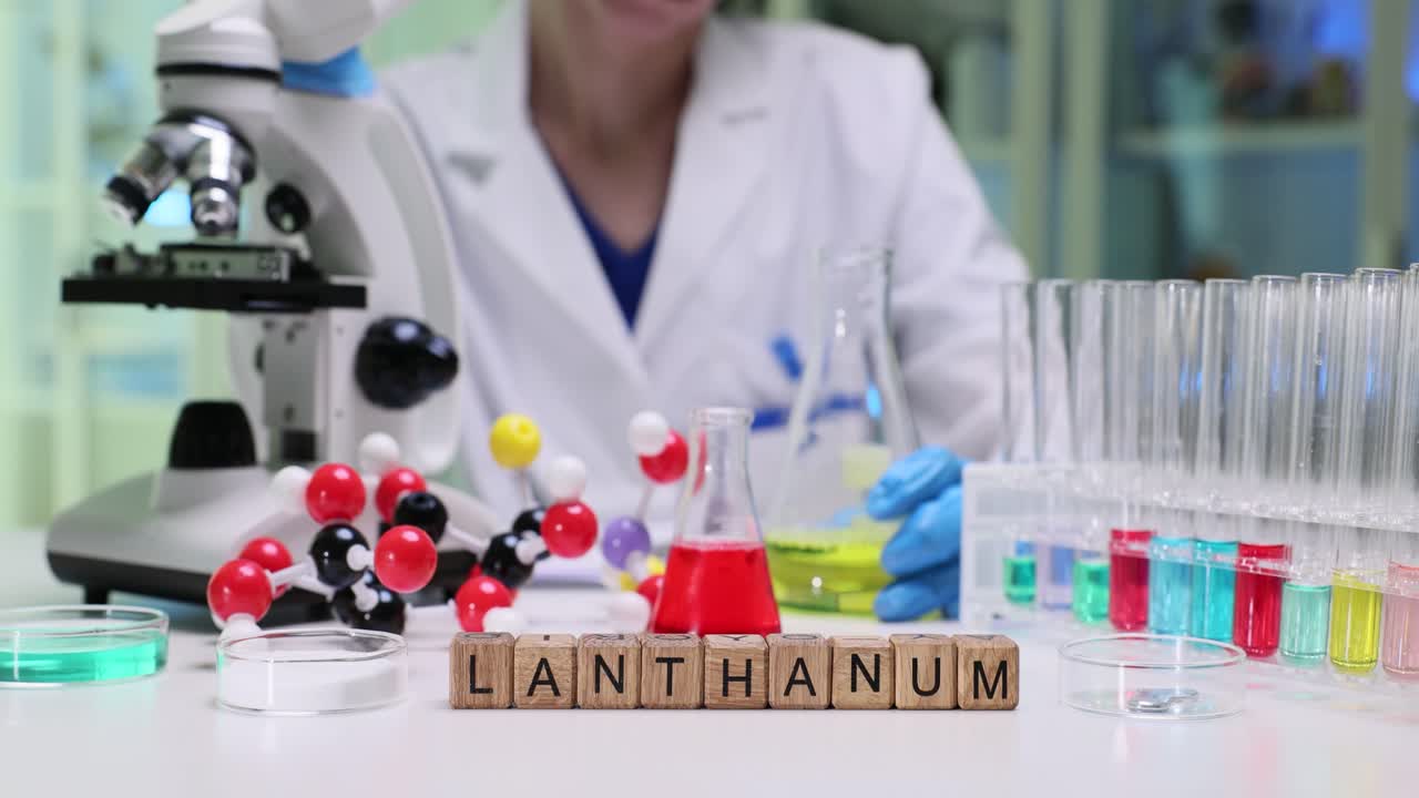 Scientist in a Chemical Laboratory with Lanthanum Experiment