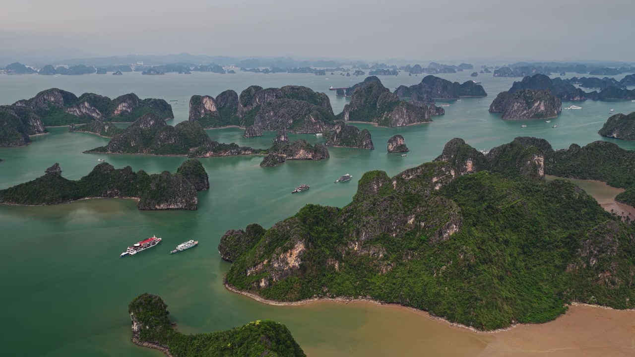 Vịnh Hạ Long Việt Nam: Cảnh quay trên không bay vòng quanh các đảo đá vôi và tàu du lịch trên làn nước xanh ngọc bích.