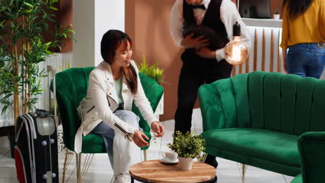 Professional-waiter-serving-coffee-for-asian-client-at-hotel