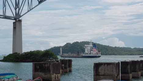 boat going under bridge of the americas over panama canal