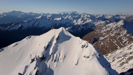 Ein-Mann-Mit-Skiern-Erklimmt-Abgelegene,-Schneebedeckte-Berge-In-Der-Wilden-Natur