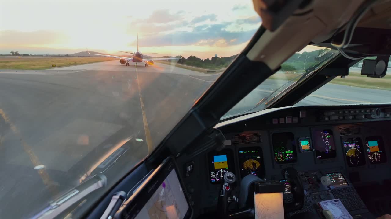 A Pilot’s FPV from inside a jet cockpit during the taxi along an airport taxiway, following another Jet Airplane for departure at sunset. Captain FPV.