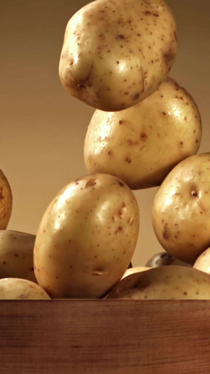 Patate Crude che Cadono in una Ciotola di Legno al Rallentatore