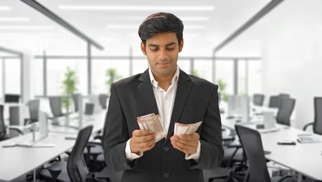 Glücklicher-Indischer-Manager,-Der-Im-Büro-Geld-Zählt