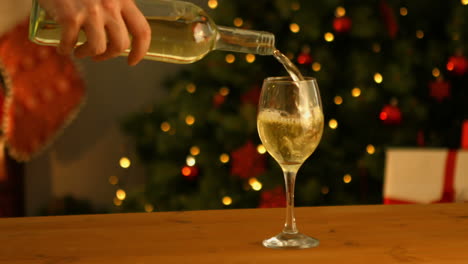 mano vertiendo un vaso de vino