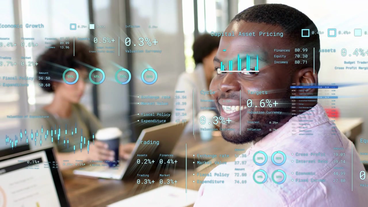 Pointing and typing, adult man in light button-down working at wooden table, HUD charts, laptop