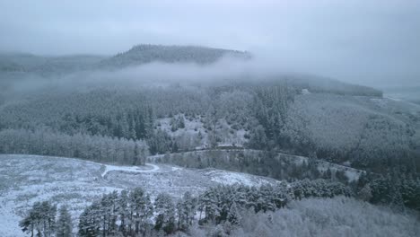 Winter-woodland-landscape-with-misty-wooded-fells