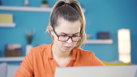 Young-woman-working-in-her-home-office,-serious-and-focused.