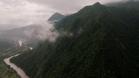 paisaje brumoso y sombrío en quietud: colinas salvajes y nubladas y río sinuoso