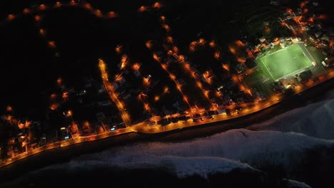 experience the magic of madeira at sunset with this aerial video, as the waves crash against the shore and the lights of the city reflect on the water, creating a stunning evening scene