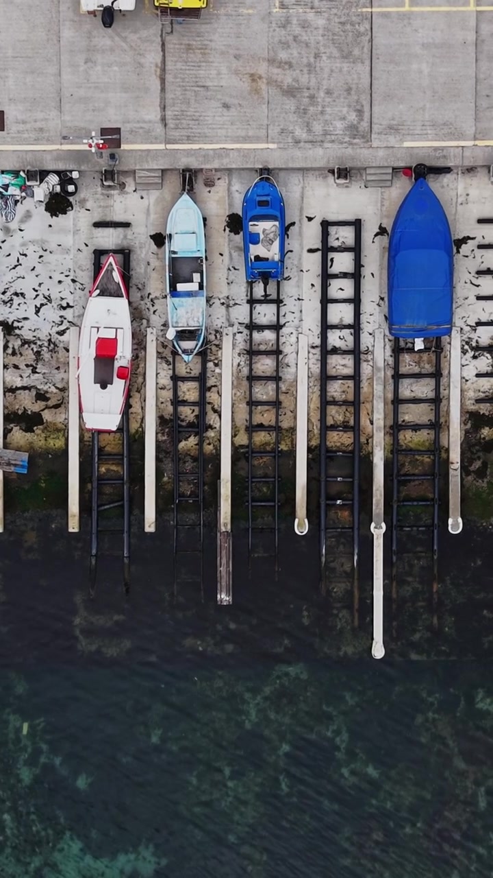 Boats docked at the harbor during daylight hours in a coastal area