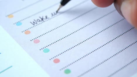 person writing daily schedule in planner