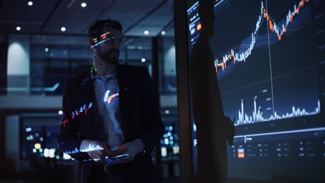 presentación en una conferencia de negocios: un empresario hace un análisis financiero y habla con un grupo de empresarios. la pantalla del proyector muestra datos del mercado de valores, estrategia de inversión, crecimiento de los ingresos