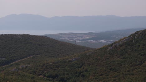 aerial view of mountains, hills, forest, and sea