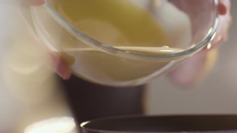 close up of man in kitchen at home pouring mixture into tin to bake cake 2