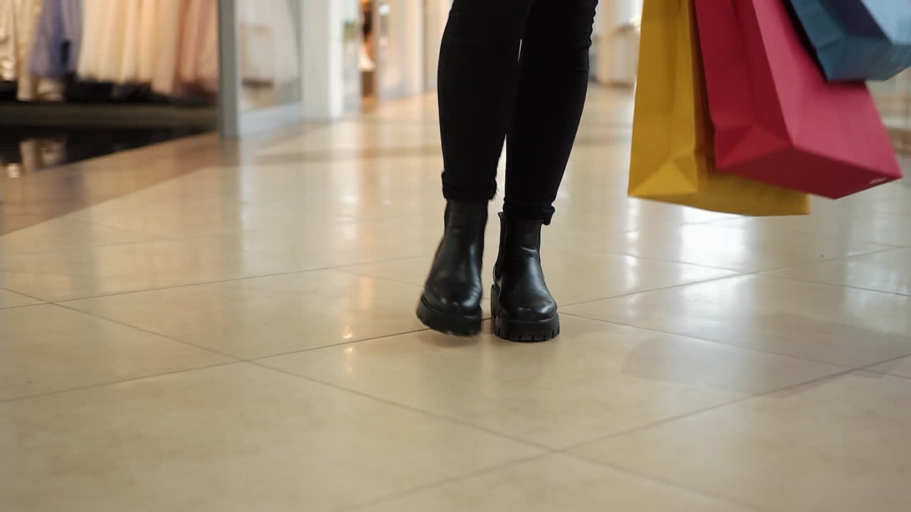 Woman walking with shopping bags in a mall
