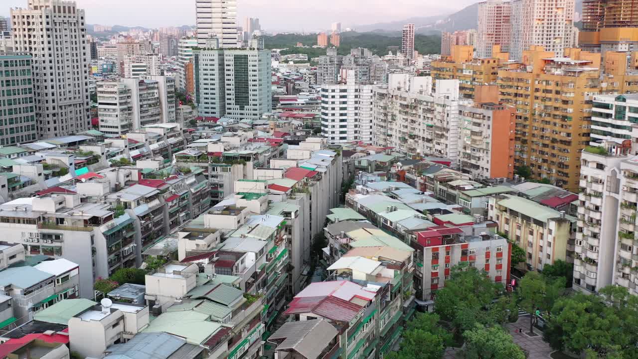 대만 수도 타이페이 신이 지구 용춘에 있는 오래된 주거용 건물과 초기 개발 중인 부동산과 현대적인 새 고층 건물을 캡처하는 틸트 샷의 공중 느린 돌리