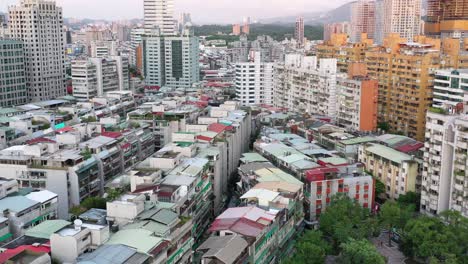 aerial slow dolly in tilt shot capturing a mix of old residential buildings and properties in early development and modern new skyscrapers at yongchun, xinyi district, capital city taipei, taiwan