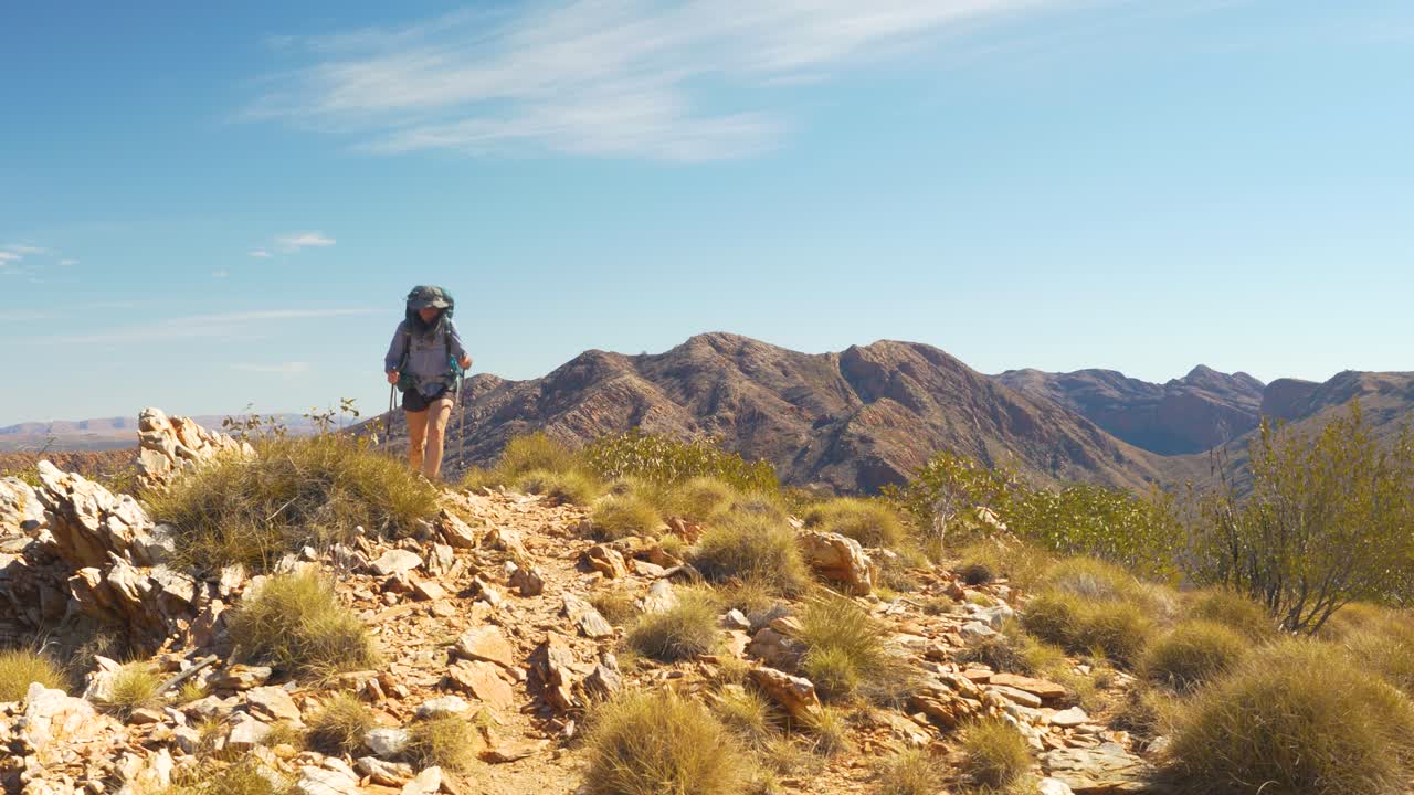 excursionista se acerca a la cámara a lo largo de la escarpada cordillera, australia central