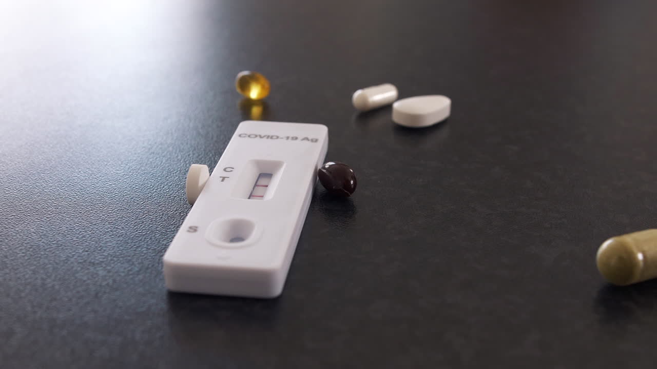 ponga a mano un puñado de suplementos sobre la mesa cerca de la prueba de covid