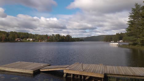 a beautiful day at a cottage in rural canada with a large dock leading up to a lake during the summer