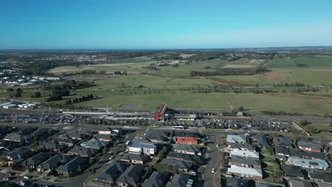 AERIAL-Orbiting-Suburban-Train-Station-On-Sunny-Morning