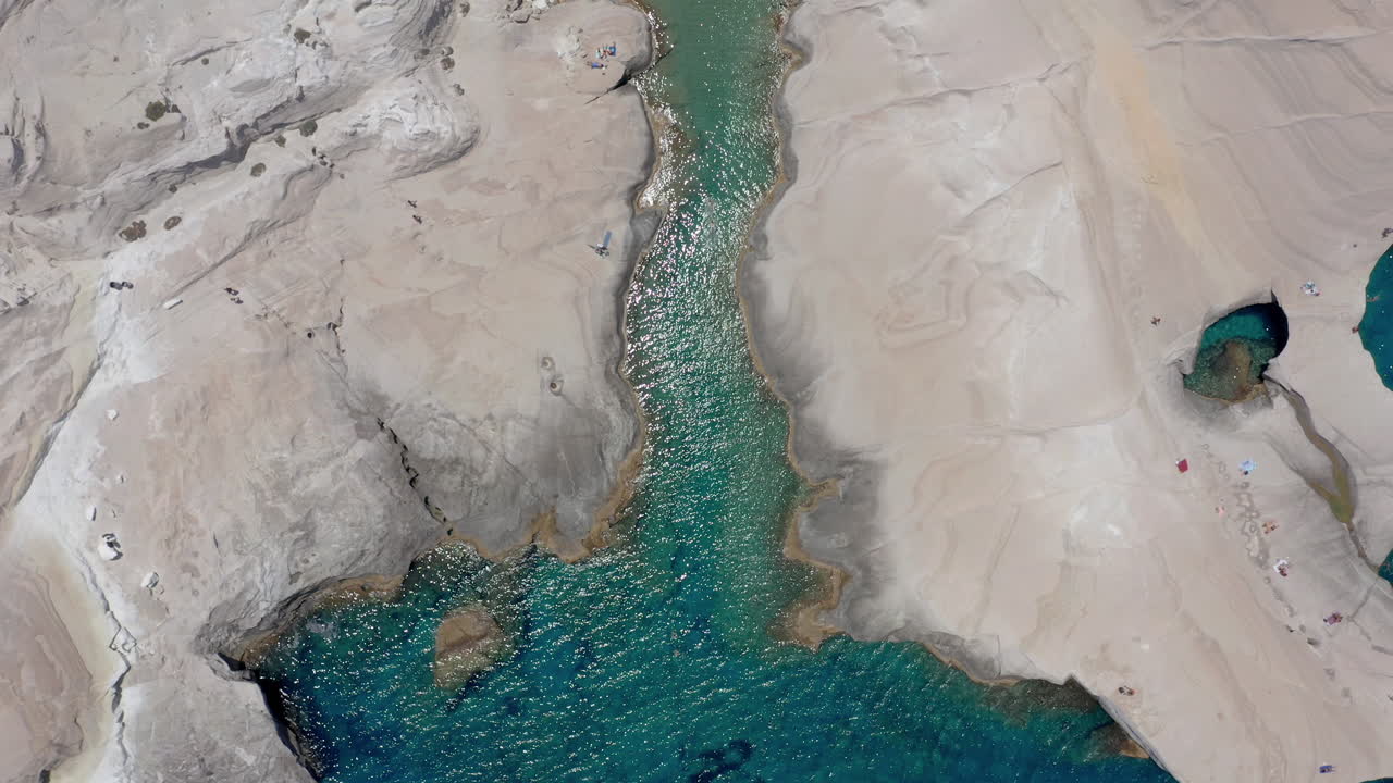 Aerea: Splendida veduta dall'alto in ascesa della spiaggia di Sarakiniko nell'isola di Milos, Cicladi, Grecia, con acqua cristallina color smeraldo a mezzogiorno