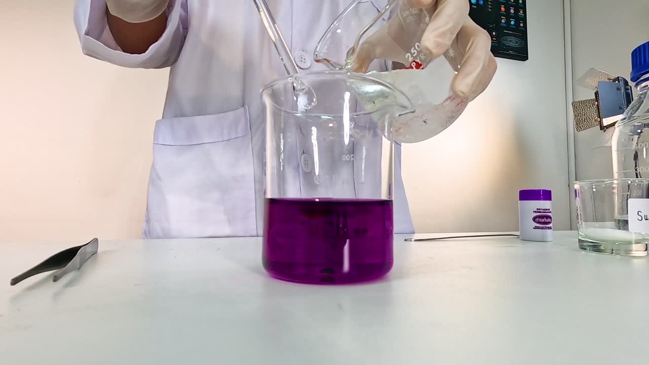 A scientist demonstrates a chemical reaction causing a color change in a beaker over 45 seconds