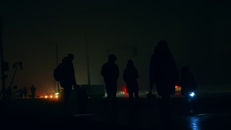 people walking on a foggy night street