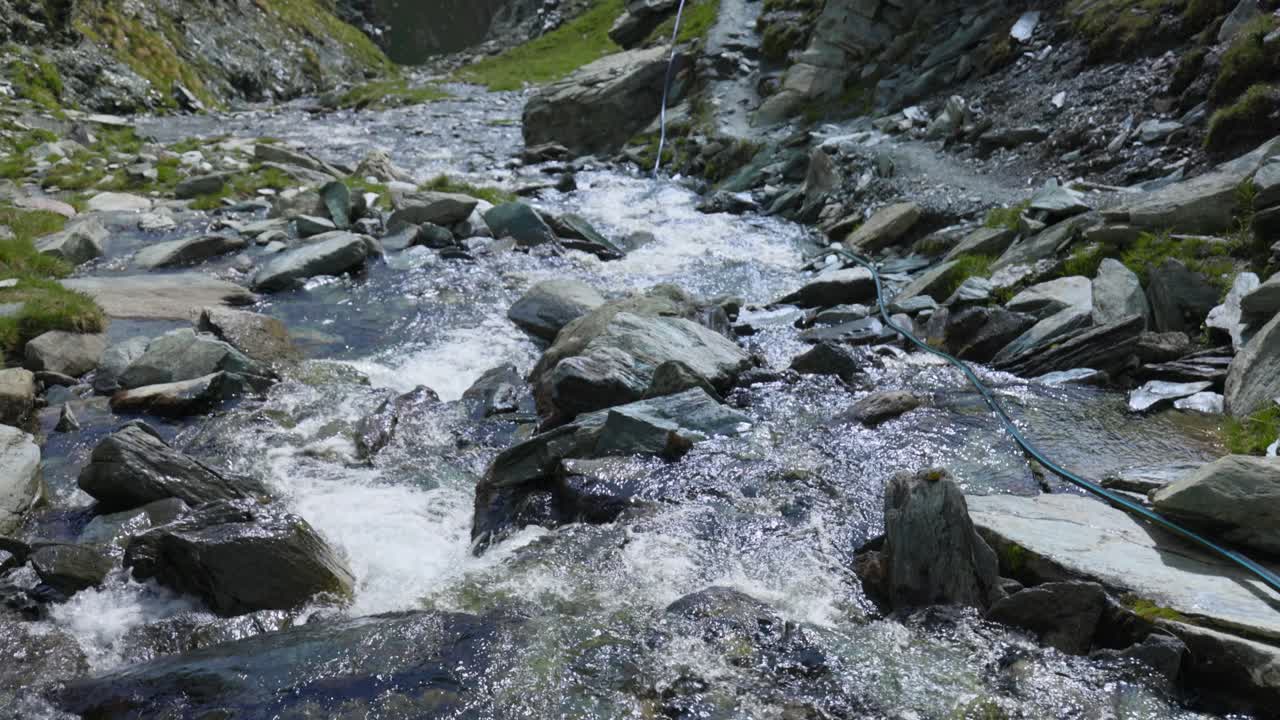 Peaceful river stream, tilt up reveal breathtaking mountains in Valmalenco