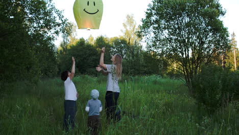 Madre-Con-Dos-Hijos-Volando-Sonriendo-Linterna-De-Fuego