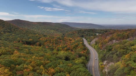 Eine-Luftaufnahme-Hoch-über-Den-Bergen-Im-Hinterland-Von-Ny-Im-Herbst-An-Einem-Schönen-Tag-Mit-Weißen-Wolken